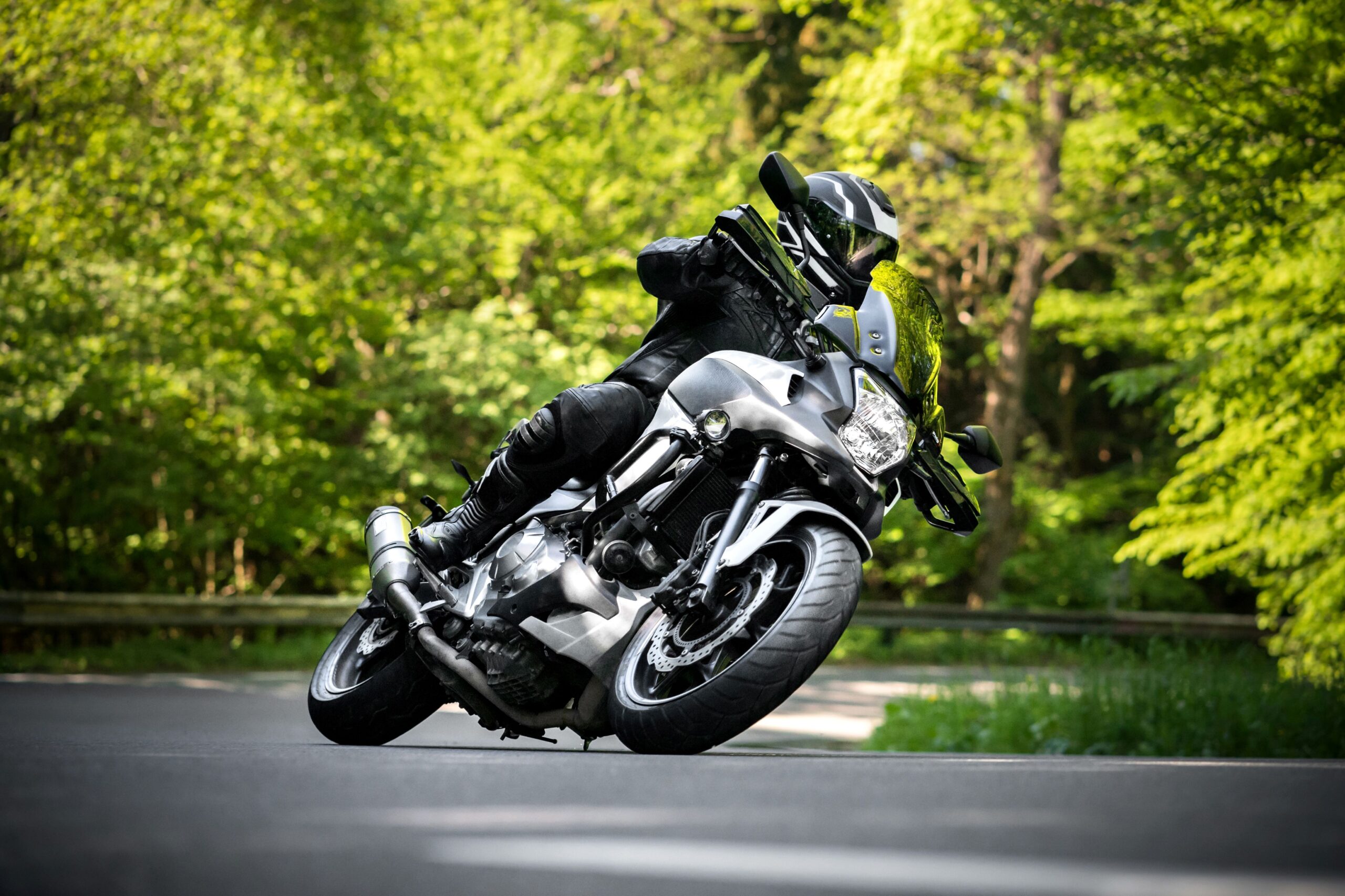 Motorradfahrer mit HJC Klapphelm fährt konzentriert durch eine Kurve im Wald