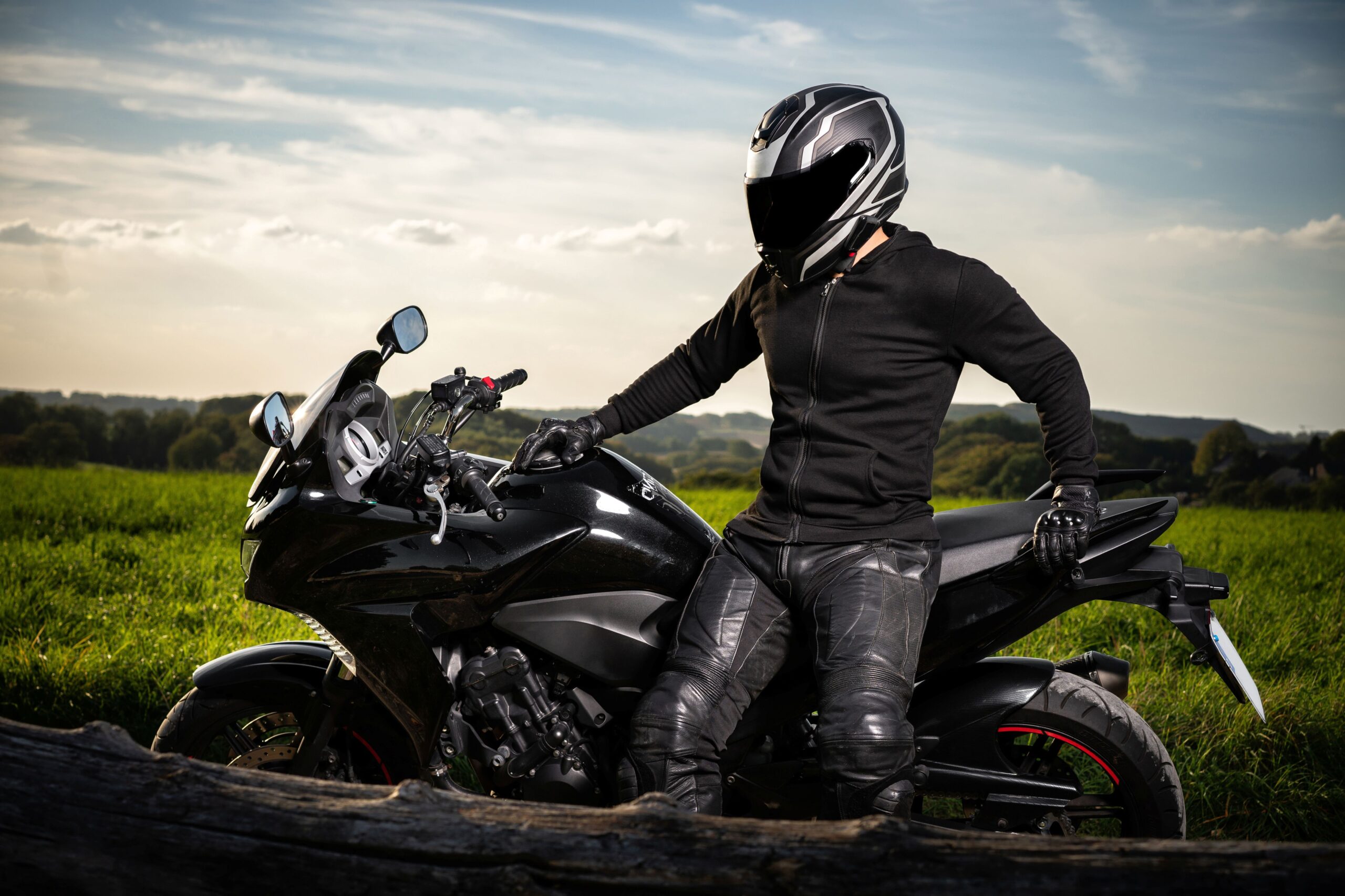 Motorradfahrer mit HJC Klapphelm sitzt entspannt auf seiner Maschine vor weiter Landschaft
