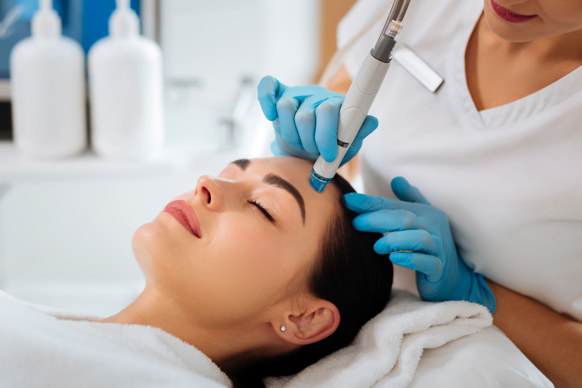 Professionelle Kosmetikerin führt eine Hydrafacial Behandlung an einer Frau durch – modernes Hautpflegeverfahren mit nachhaltigem Fokus